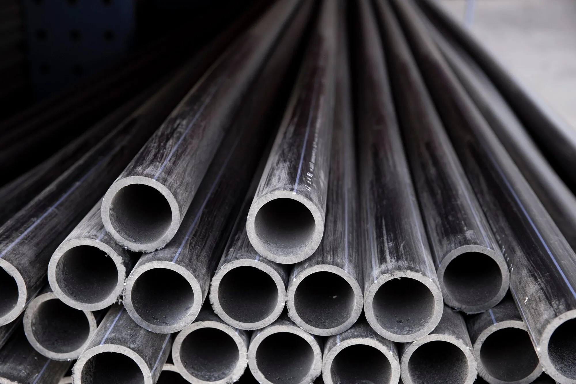 Industrial steel pipes arranged in rows, showcasing various diameters for different applications
